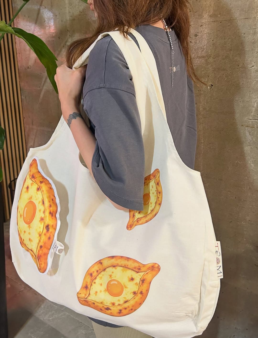 Model carrying the khachapuri shopper over one shoulder